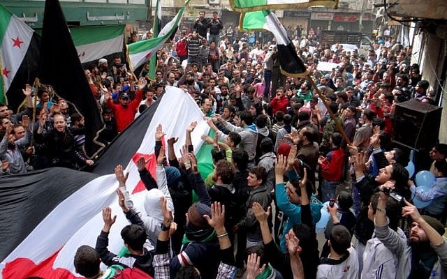 In this citizen journalism image provided by Aleppo Media Center AMC which has been authenticated based on its contents and other AP reporting, anti-Syrian regime protesters raise up their hands as they wave Syrian revolutionary flags during a protest to mark the second anniversary of the their uprising, in Aleppo, Syria, Friday March 15, 2013. The chief of Syria's main, western-backed rebel group marked the second anniversary of the start of the uprising against President Bashar Assad on Friday by pledging to fight until the "criminal" regime is gone. (AP Photo/Aleppo Media Center, AMC) In this citizen journalism image provided by Aleppo Media Center AMC which has been authenticated based on its contents and other AP reporting, anti-Syrian regime protesters raise up their hands as they wave Syrian revolutionary flags during a protest to mark the second anniversary of the their uprising, in Aleppo, Syria, Friday March 15, 2013. The chief of Syria's main, western-backed rebel group marked the second anniversary of the start of the uprising against President Bashar Assad on Friday by pledging to fight until the "criminal" regime is gone. (AP Photo/Aleppo Media Center, AMC)