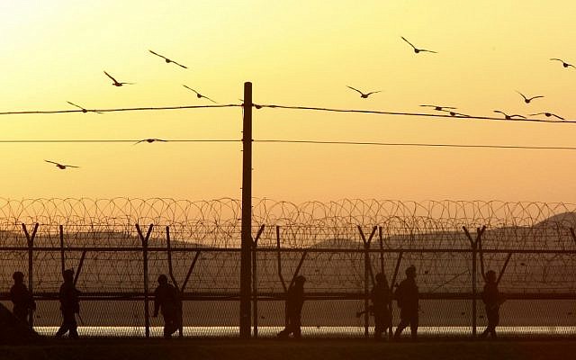 South Korean army soldiers patrol along a barbed-wire fence near the border village of Panmunjom in Paju, South Korea, on Tuesday evening, March 26, 2013. (photo credit: AP Photo/Ahn Young-joon) South Korean army soldiers patrol along a barbed-wire fence near the border village of Panmunjom in Paju, South Korea, on Tuesday evening, March 26, 2013. (photo credit: AP Photo/Ahn Young-joon)