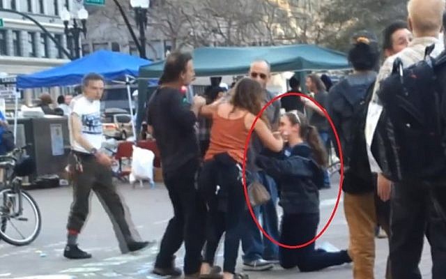 Hannah Larson (on her knees) attacked by pro-Palestinian activists in Oakland (photo credit: screen capture Alba5431/Youtube) Hannah Larson (on her knees) attacked by pro-Palestinian activists in Oakland (photo credit: screen capture Alba5431/Youtube)