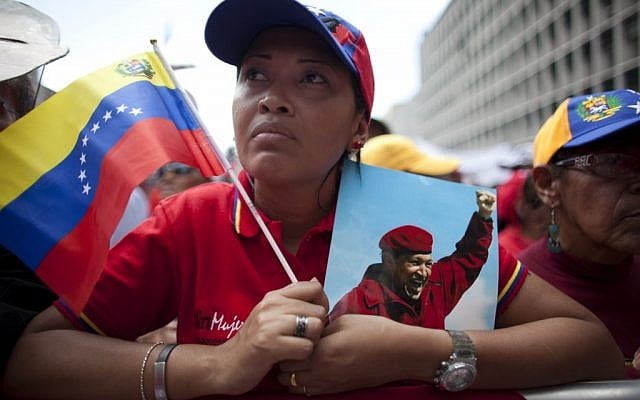 A woman holds a picture of Venezuela's President Hugo Chavez and the country's national flag in Caracas, Venezuela last Wednesday. (photo credit: AP/Ariana Cubillos) A woman holds a picture of Venezuela's President Hugo Chavez and the country's national flag in Caracas, Venezuela last Wednesday. (photo credit: AP/Ariana Cubillos)