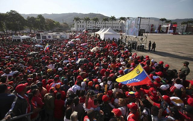 People gather outside the military academy where the funeral ceremony for Venezuela's late President Hugo Chavez will take place in Caracas, Venezuela, Friday, March 8, 2013. (photo credit: AP/Fernando Llano) People gather outside the military academy where the funeral ceremony for Venezuela's late President Hugo Chavez will take place in Caracas, Venezuela, Friday, March 8, 2013. (photo credit: AP/Fernando Llano)