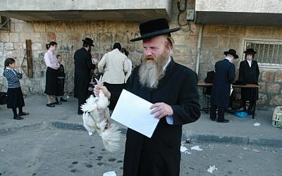 Illustrative photo of an Ultra-Orthodox Jewish man holding a chicken later to be slaughtered as part of a Kaparot ritual (photo credit: Pierre Terdjman /Flash90)