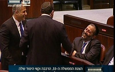Finance Minister Yair Lapid, left, and Education Minister Shai Piron talking to Shas's Aryeh Deri in the Knesset Monday. (Screenshot: Knesset Channel)