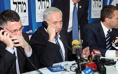 Then-minister of education Gideon Sa'ar (left) and then-minister of environment Gilad Erdan (right) flank Prime Minister Benjamin Netanyahu as they make calls to potential voters ahead of national elections, in Tel Aviv, January 17, 2013. (Gideon Markowicz/ Flash90)