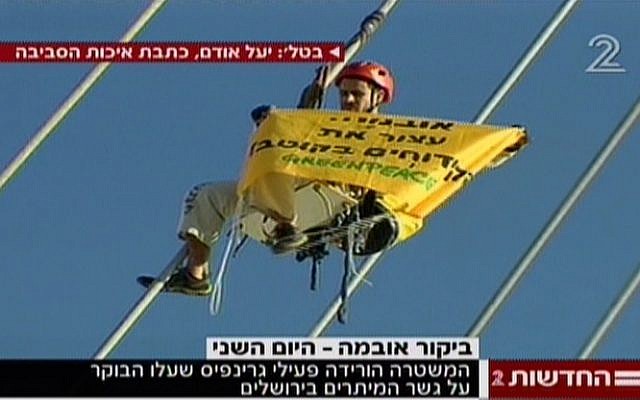 A Greenpeace activist on the Bridge of Strings in Jerusalem on Thursday. (Screenshot: Channel 2)