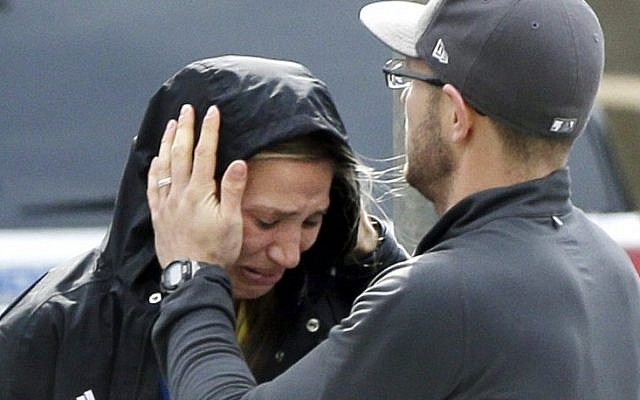 An unidentified runner is comforted in the aftermath of two blasts that exploded near the finish line of the Boston Marathon on Monday, April 15, 2013. (photo credit: AP/Elise Amendola) An unidentified runner is comforted in the aftermath of two blasts that exploded near the finish line of the Boston Marathon on Monday, April 15, 2013. (photo credit: AP/Elise Amendola)