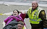 Medical workers aid an injured woman at the finish line of the 2013 Boston Marathon, on April 15, 2013. (photo credit: AP/Charles Krupa)