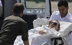Egyptian medics and army personnel carry former Egyptian president Hosni Mubarak, 84, from a helicopter ambulance after it lands in Maadi Military Hospital following his adjourned trial in Cairo, Egypt, Saturday, April 13, 2013. Egypt's highest court in January ordered a retrial for Mubarak for failing to stop the killing of 900 protestors in the 2011 unrest that ousted him, after accepting an appeal against his life sentence, citing procedural failings. (AP Photo/Amr Nabil)