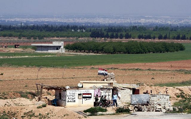 Syrian soldiers at a Syrian army post as seen from the Lebanese border village of al-Qasr, Lebanon, Friday, April 12, 2013. Syrian warplanes and troops battled rebels near the border with Lebanon as part of a widening government counteroffensive to recapture territory along strategic border areas and near the capital Damascus. Written on the army post are the words 'only God, Syria and Bashar' and 'God is protecting Syria.' (AP Photo/Bilal Hussein) Syrian soldiers at a Syrian army post as seen from the Lebanese border village of al-Qasr, Lebanon, Friday, April 12, 2013. Syrian warplanes and troops battled rebels near the border with Lebanon as part of a widening government counteroffensive to recapture territory along strategic border areas and near the capital Damascus. Written on the army post are the words 'only God, Syria and Bashar' and 'God is protecting Syria.' (AP Photo/Bilal Hussein)