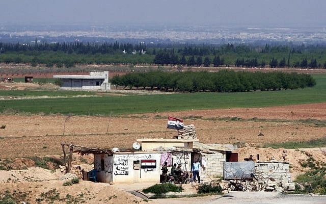 Syrian soldiers at a Syrian army post as seen from the Lebanese border village of al-Qasr, Lebanon, Friday, April 12, 2013 (photo credit: AP/Bilal Hussein) Syrian soldiers at a Syrian army post as seen from the Lebanese border village of al-Qasr, Lebanon, Friday, April 12, 2013 (photo credit: AP/Bilal Hussein)