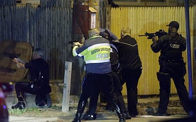 Police officers aim their weapons on Friday at the start of the lockdown in Watertown, Massachusetts (photo credit: AP/Matt Rourke)