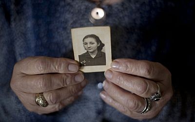 In this April 4, 2013 photo, Warsaw Ghetto Holocaust survivor Aliza Vitis-Shomron, nee Mendel, holds a photograph of herself when she was about 17 years old as she sits in her living room in Kibbutz Givat Oz, Israel. (AP/Ariel Schalit)