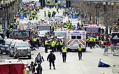 Police clear the area at the finish line of the 2013 Boston Marathon as medical workers help injured following explosions in Boston, Monday, April 15, 2013 (photo credit: AP/Charles Krupa)