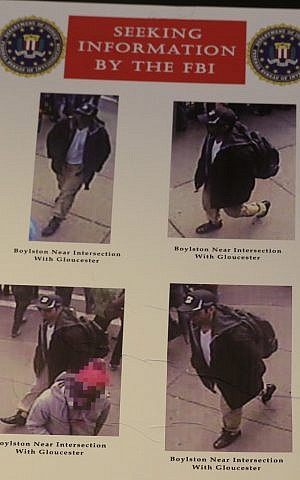 Photos of one of two suspects sought in the Boston Marathon bombing is displayed during a news conference talking about the investigation of the Boston Marathon explosions, Thursday, April 18, 2013, in Boston. (photo credit: AP/Julio Cortez)