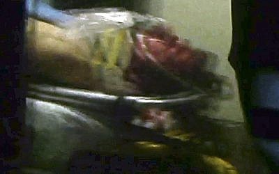 This still frame from video shows Boston Marathon bombing suspect Dzhokhar Tsarnaev visible through an ambulance after he was captured in Watertown, Mass., Friday, April 19, 2013. (photo credit: AP/Robert Ray)