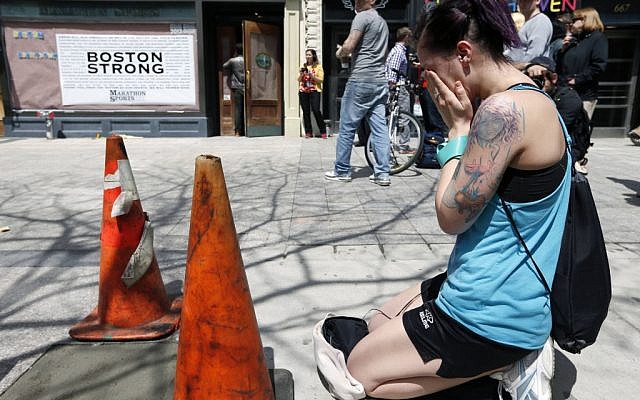 Hillary Branyik, of Boston, kneels at the site where the first bomb detonated on April 15 near the finish line of the Boston Marathon on Boylston Street in Boston, on, April 24, 2013. (AP/Michael Dwyer) Hillary Branyik, of Boston, kneels at the site where the first bomb detonated on April 15 near the finish line of the Boston Marathon on Boylston Street in Boston, on, April 24, 2013. (AP/Michael Dwyer)