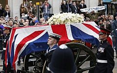 A Union flag draped coffin bearing the body of former British Prime Minister Margaret Thatcher is carried on a gun carriage drawn by the King's Troop Royal Artillery during her ceremonial funeral procession in London, on Wednesday, April 17, 2013.  (photo credit: AP Photo/Matt Dunham, Pool)