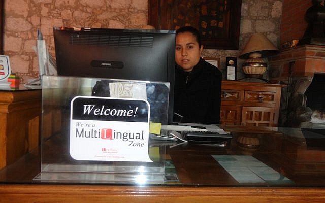 A woman at a hotel reception desk in Mexico uses the Lexifone app to speak to clients from abroad (Photo credit: Courtesy) A woman at a hotel reception desk in Mexico uses the Lexifone app to speak to clients from abroad (Photo credit: Courtesy)