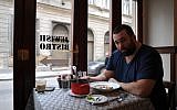 David Popovits, owner of the Matzah Soldier, sits down for a meal at his upscale restaurant in Budapest, March 2013. (photo credit: Cnaan Liphshiz/JTA)