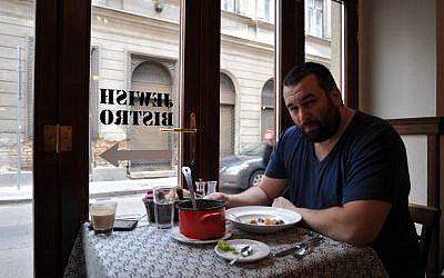 David Popovits, owner of the Matzah Soldier, sits down for a meal at his upscale restaurant in Budapest, March 2013. (photo credit: Cnaan Liphshiz/JTA)