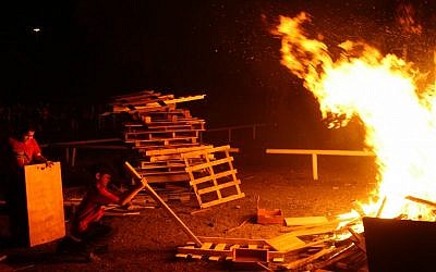 Throwing boards onto the growing bonfire in Ramat Gan. (photo credit: Chen Leopold/Flash 90)