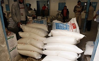 Palestinians receive their monthly food aid at a UN distribution center in the Rafah refugee camp in the southern Gaza Strip in November 2012 (Abed Rahim Khatib/Flash 90)