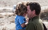 A reservist says goodbye to his child at Mishmar Hanegev, as the IDF prepares for an offensive in Gaza, November 2012 (photo credit: Uri Lenz/Flash90)