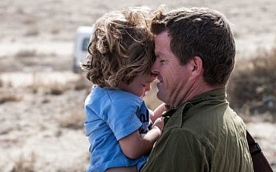 A reservist says goodbye to his child at Mishmar Hanegev, as the IDF prepares for an offensive in Gaza, November 2012 (photo credit: Uri Lenz/Flash90)