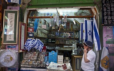 A Jewish child stands at the entrance to a shop in Jerusalem's Old City on March 27, 2013, during the Passover holiday (photo credit: Sliman Khader/Flash90)