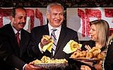 Prime Minister Benjamin Netanyau and his wife Sara enjoy 'mufletot' and traditional sweets at a colorful North African Mimouna celebration in Or Akiva, Monday. (photo credit: Avishag Shaar Yashuv/Flash90)