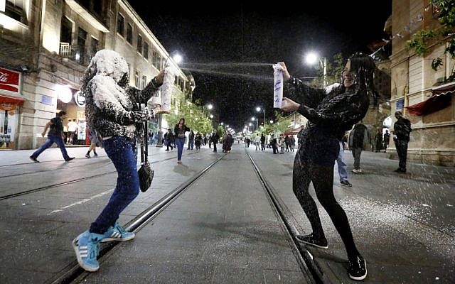Israelis spraying each other with fake snow in Jerusalem Monday night. (photo credit: Miriam Alster/Flash90) Israelis spraying each other with fake snow in Jerusalem Monday night. (photo credit: Miriam Alster/Flash90)