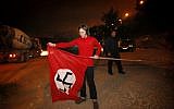 Police watch as Meir Schijveschuurder, whose family members were murdered in a suicide bombing attack at the Sbarro restaurant in Jerusalem in 2001, removes a Nazi flag which he hung in protest on his land outside of Jerusalem.  April 16, 2013. (photo credit: Miriam Alster/Flash90)