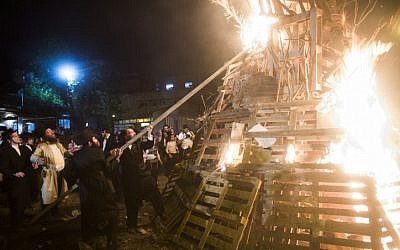 Ultra-Orthodox men set light to a massive bonfire during celebrations of the holiday of Lag B'Omer in Jerusalem on Saturday, April 27, 2013. (photo credit: Yonatan Sindel/Flash90)