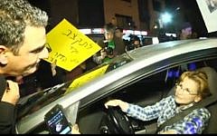 Health Minister Yael German speaks to protesters upon leaving a Yesh Atid faction meeting April 13 (image capture/YouTube)