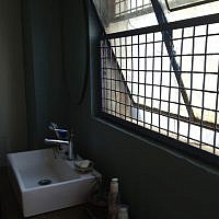 Accommodating massive windows above the bathroom sink and commode (photo credit: Jessica Steinberg/Times of Israel)