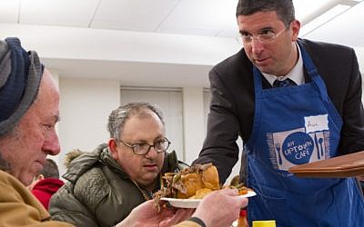 Deputy Education Minister MK Avi Wortzman (Jewish Home) helps serve dinner to guests at the Chicago Federation’s kosher, restaurant-style hunger program for the city's impoverished residents. (photo credit: Steve Donisch)