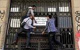 Egyptian protesters hang an Arabic banner reading, “people demand an arrest warrant to the prosecutor general” during a protest in front of the prosecutor general's office in Cairo, Egypt, Friday, March 29, 2013. (Photo credit: AP/Amr Nabil)