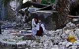 An Iranian woman reacts as she sits among the rubble of buildings after an earthquake struck southern Iran, in Shonbeh, Iran in April. (photo credit: AP/Fars News Agency, Mohammad Fatemi)