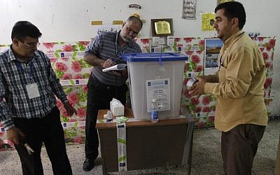 Iraqi election officials check the seals on a ballot box before the country's provincial elections at a polling center in Baghdad, Iraq, Saturday, April 20, 2013.  (AP Photo/ Khalid Mohammed)