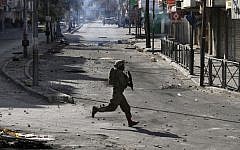 An Israeli soldier in Hebron during clashes with Palestinians in April. (photo credit: AP/Nasser Shiyoukhi)