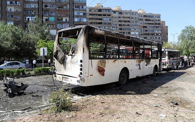This photo released by the Syrian official news agency SANA, shows Syrians inspecting a damaged car at the scene of a car bomb exploded in the capital's western neighborhood of Mazzeh, in Damascus, Syria, Monday, April. 29, 2013. (photo credit: AP/SANA) This photo released by the Syrian official news agency SANA, shows Syrians inspecting a damaged car at the scene of a car bomb exploded in the capital's western neighborhood of Mazzeh, in Damascus, Syria, Monday, April. 29, 2013. (photo credit: AP/SANA)