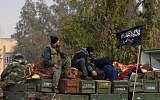 This Friday, Jan. 11, 2013 file citizen journalism image shows rebels from al-Qaida affiliated Jabhat al-Nusra, as they sit on a truck full of ammunition, at Taftanaz air base, that was captured by the rebels, in Idlib province, northern Syria (photo credit: AP/ENN)
