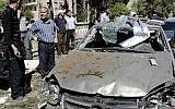 This photo released by the Syrian official news agency SANA, shows Syrians inspecting a damaged car at the scene of a car bomb exploded in the capital's western neighborhood of Mazzeh, in Damascus, Syria, Monday, April. 29, 2013 (photo credit: AP/SANA)