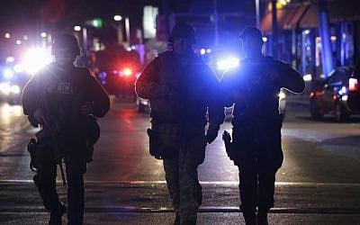Officers wearing tactical gear arrive in Watertown, near Boston, on Friday (photo credit: AP/Julio Cortez)