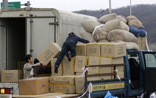 A South Korean man, center, unloads boxes transported from North Korea's Kaesong upon arrival at the customs, immigration and quarantine office near the border village of Panmunjom, which has separated the two Koreas since the Korean War, in Paju, north of Seoul, South Korea, on Tuesday. (photo credit: AP Photo/Lee Jin-man) A South Korean man, center, unloads boxes transported from North Korea's Kaesong upon arrival at the customs, immigration and quarantine office near the border village of Panmunjom, which has separated the two Koreas since the Korean War, in Paju, north of Seoul, South Korea, on Tuesday. (photo credit: AP Photo/Lee Jin-man)