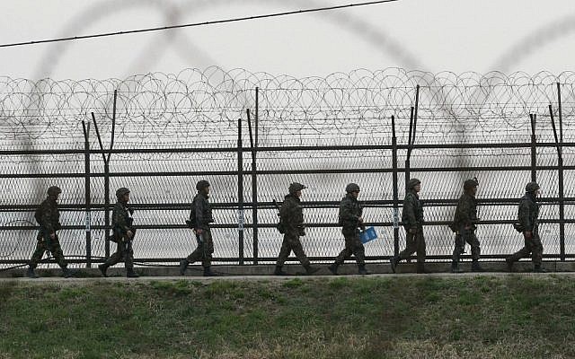 South Korean army soldiers patrol along a barbed-wire fence in Paju near the border village of Panmunjom, April 17, 2013 (photo credit: Ahn Young-joon/AP) South Korean army soldiers patrol along a barbed-wire fence in Paju near the border village of Panmunjom, April 17, 2013 (photo credit: Ahn Young-joon/AP)