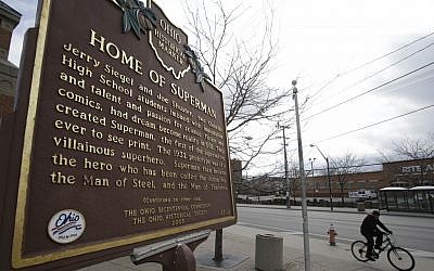 A man riding his bicycle past the Home of Superman plaque in Cleveland. (photo credit: AP Photo/Tony Dejak)