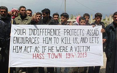 Anti-Syrian regime protesters carry a banner during a demonstration in Idlib province, northern Syria, last month. (photo credit: AP/Edlib News Network ENN)