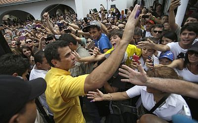 Opposition presidential candidate Henrique Capriles greets supporters after voting in the presidential election outside a polling station in Caracas, Venezuela, Sunday, April 14, 2013. Capriles is running for president against Nicolas Maduro, the hand picked successor of late President Hugo Chavez. (photo credit: AP/Fernando Llano)
