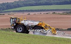 A Lite-Trac four-wheeled self-propelled crop sprayer spraying pesticide on a field (photo credit: Lite-Trac/Wikipedia Commons)